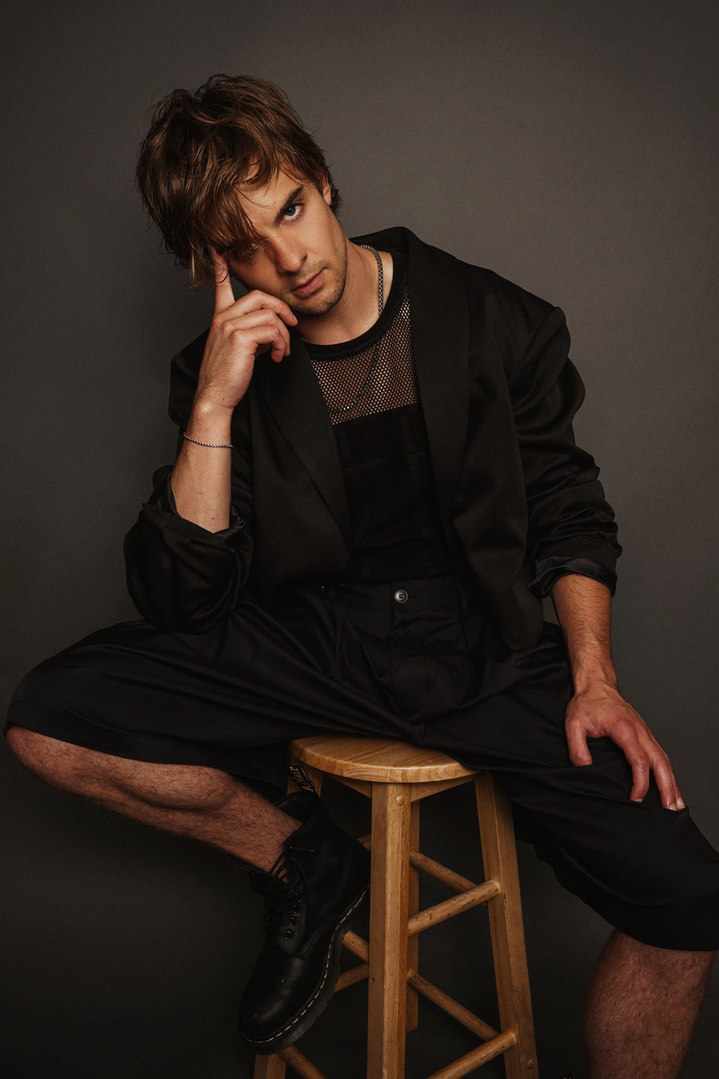 Jake Crossman seated on a stool in a black jacket